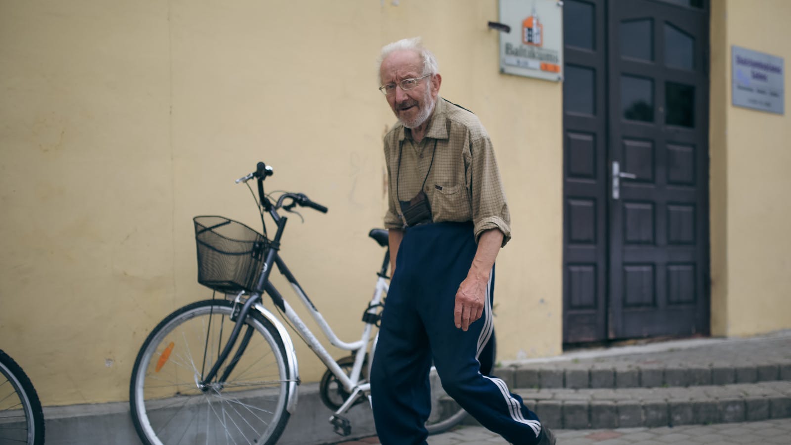 An older adult walking outside, illustrating comfort and mobility when choosing walking shoes.